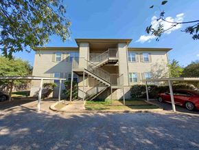 Marble Falls apartment for rent - A two-story residential building with a red car parked in front.