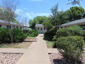 Marble Falls apartment for rent - a sidewalk in front of a house with bushes and trees