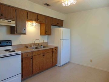 Marble Falls apartment for rent - a kitchen with white appliances and wooden cabinets
