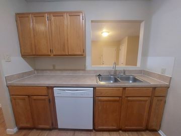 Marble Falls apartment for rent - A kitchen with wooden cabinets and a white dishwasher.