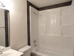 Kingsland apartment for rent - A white toilet sits next to a white sink in a small bathroom.
