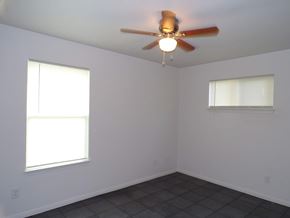Kingsland apartment for rent - A room with a ceiling fan and two windows.