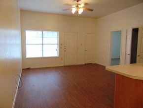 Kingsland apartment for rent - an empty living room with wood floors and a ceiling fan