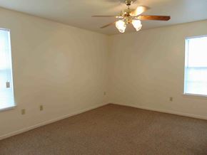 Kingsland apartment for rent - A room with a ceiling fan and carpeted floor.
