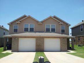 Marble Falls apartment for rent - a tan house with two garage doors