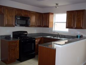 Marble Falls apartment for rent - A kitchen with wooden cabinets and a black stove top oven.