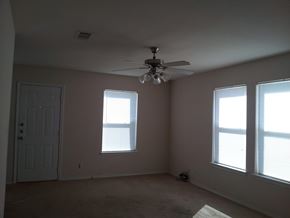 Marble Falls apartment for rent - A room with a ceiling fan and two windows.