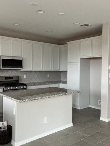 Surprise house for rent - a kitchen with white cabinets and a counter top