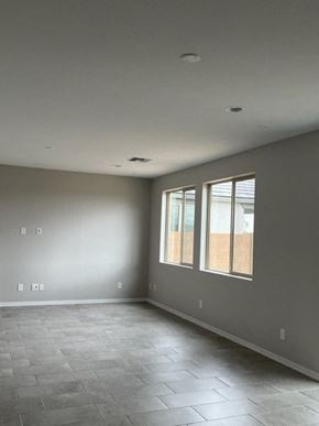 Surprise house for rent - an empty living room with windows and a tiled floor