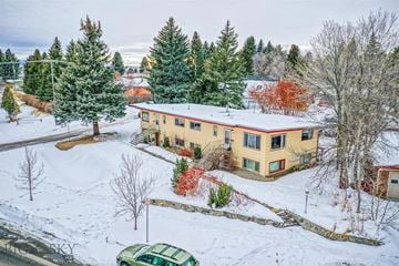 Bozeman apartment for rent - a yellow house with a red roof in the snow