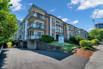 Burnaby apartment for rent - A multi-story residential building with a parking area in front.
