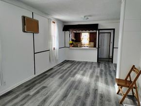 Gary house for rent - A room with a wooden chair and a grey floor.