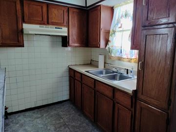 Gary house for rent - A kitchen with brown cabinets and a white dishwasher.