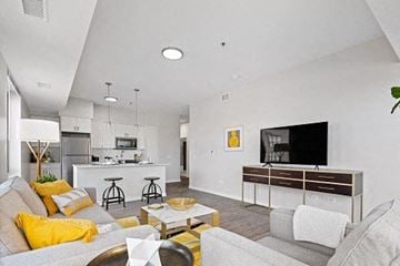 Chicago apartment for rent - A modern living room with a grey couch, yellow pillows, and a wooden coffee table.
