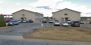 Detroit Lakes apartment for rent - A parking lot with cars parked in front of two buildings.