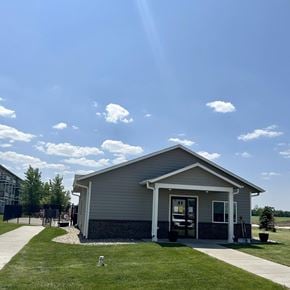 North Sioux City apartment for rent - a small gray house with a lawn and a sidewalk