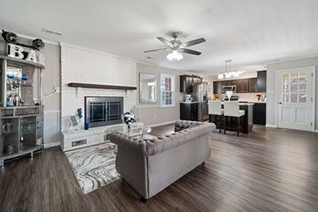 Jacksonville house for rent - A living room with a grey couch and a fireplace.