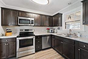 Jacksonville house for rent - A kitchen with dark brown cabinets and stainless steel appliances.