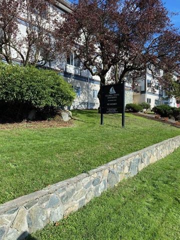 Victoria apartment for rent - A sign in a grassy area in front of a building.