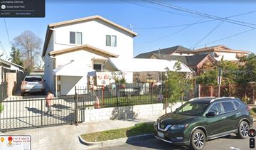 Los Angeles apartment for rent - A green car is parked in front of a white house.