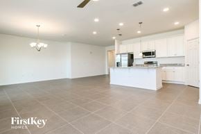 Kissimmee house for rent - A spacious kitchen with a white island and a chandelier hanging from the ceiling.