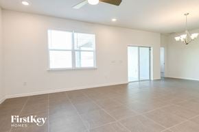 Kissimmee house for rent - A spacious room with a fan and a chandelier.