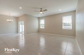Bartow house for rent - an empty living room with a ceiling fan and tiled floors