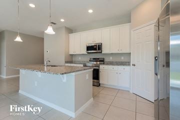 Bartow house for rent - a kitchen with white cabinets and a counter top