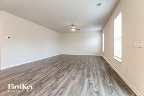 Greer house for rent - A spacious room with wooden flooring and a ceiling fan.