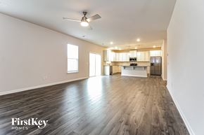 Greer house for rent - A spacious room with wooden flooring and a ceiling fan.
