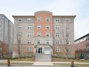 Waterloo apartment for rent - A large building with a red brick section in the middle and a white door in front.
