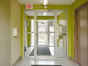 Waterloo apartment for rent - A hallway with a green wall and a white door with a glass window.