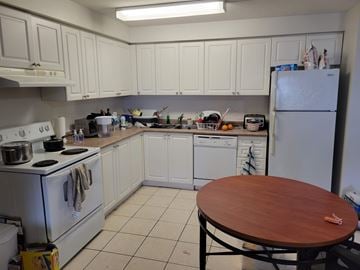 Waterloo apartment for rent - A kitchen with white appliances and wooden table.