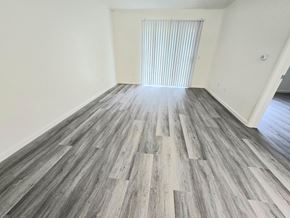 Wildomar multi-family for rent - A room with wooden flooring and a window with blinds.