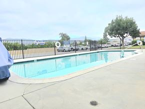 Wildomar multi-family for rent - A person in a blue shirt is sitting by a pool.