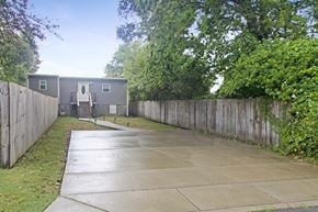Nashville house for rent - the backyard of a mobile home with a sidewalk and a fence