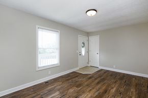 Nashville house for rent - an empty living room with wood floors and a white door