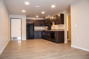 Jamestown apartment for rent - a kitchen with black appliances and dark wood cabinets