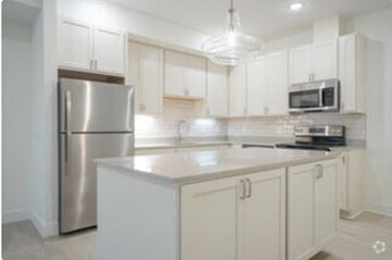 Holland apartment for rent - a kitchen with white cabinets and a stainless steel refrigerator