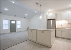 Holland apartment for rent - an empty living room with a kitchen with white cabinets