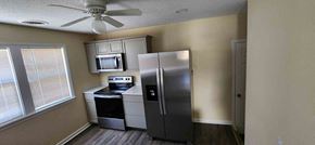 Clinton house for rent - A kitchen with a refrigerator, microwave, and oven.