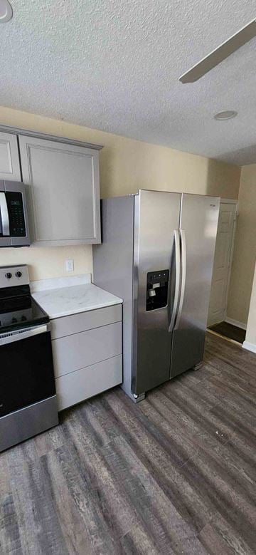 Clinton house for rent - A kitchen with a refrigerator and a stove top oven.