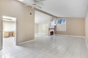 Cathedral City house for rent - A spacious room with a fireplace and a ceiling fan.