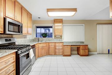 Cathedral City house for rent - A kitchen with wooden cabinets and a black stove top oven.