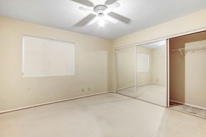 Cathedral City house for rent - A room with a ceiling fan and a large mirror.