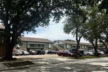 Gretna apartment for rent - a parking lot filled with cars in front of apartment buildings