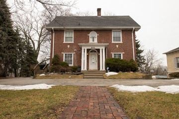 Waukegan house for rent - A red brick house with a white door and a brick pathway leading to it.