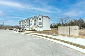 Chapel Hill house for rent - A large white building with multiple windows and balconies is surrounded by a parking lot.