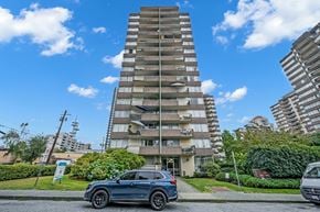 New Westminster apartment for rent - A tall residential building with a blue sky and clouds in the background.