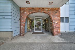 White Rock apartment for rent - A blue house with a brick archway entrance.